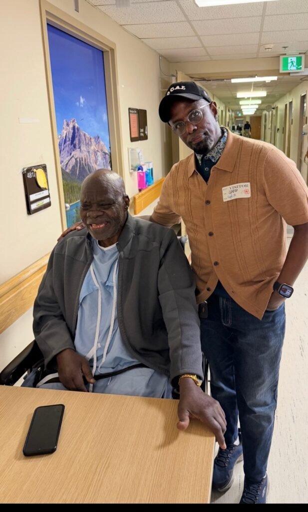 Chairman Ibrahim Shurie standing with a smiling community member in a hospital hallway