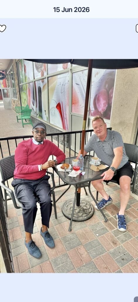 Society leader meeting with a community partner over coffee on a restaurant patio