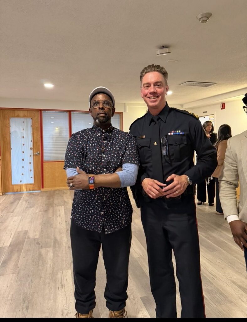 Society leader standing with a uniformed police officer at a community gathering