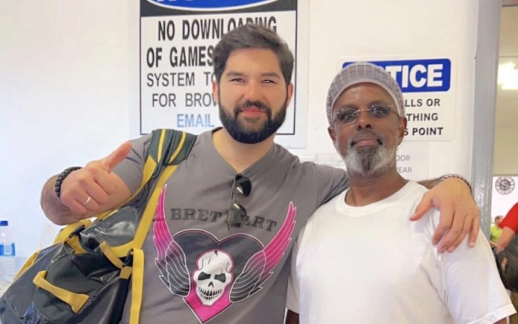 Society leader and a smiling young man giving a thumbs up in a workplace break room
