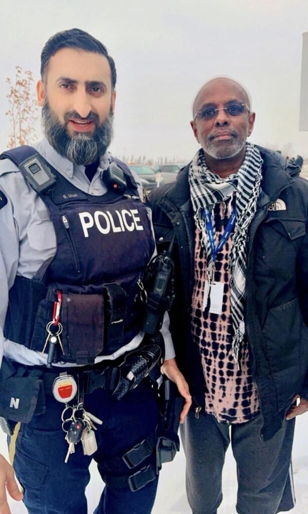 Society leader standing with an RCMP officer outdoors on a winter day