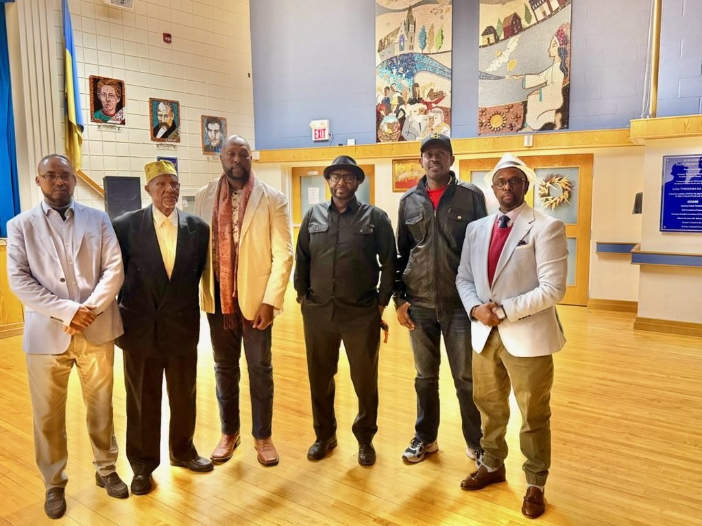 Six community members and leaders standing together in the community hall